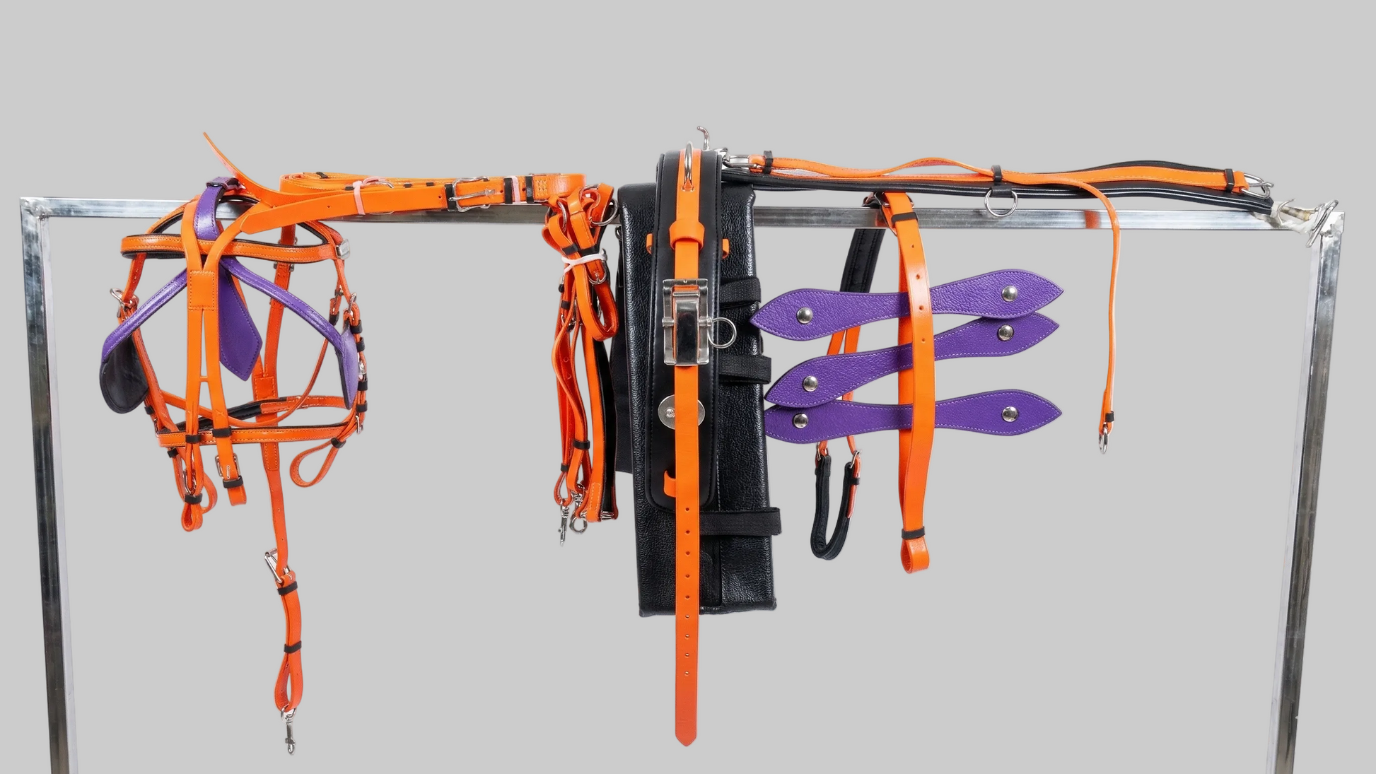 Set of orange and black straps on a metal rack against a white background