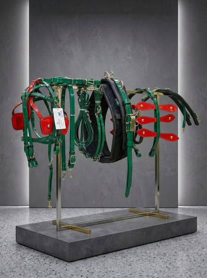 Collection of horse tack including bridles and a headstall on a stand against a gray background.